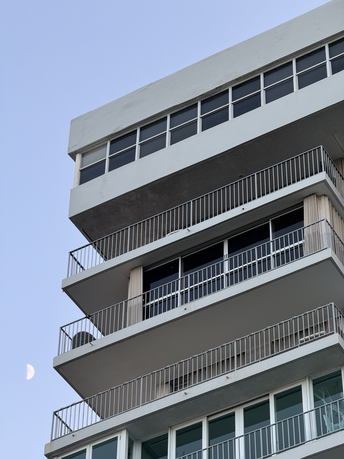 Detalle de la fachada de un condominio, con balcones y barandas en varios niveles.